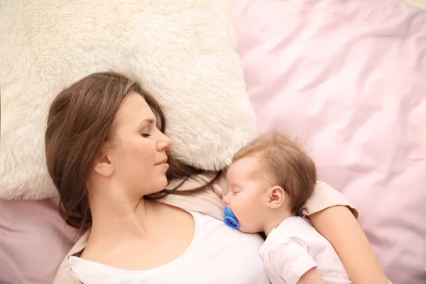 Ibu muda dan bayi lucu tidur di tempat tidur di rumah — Stok Foto