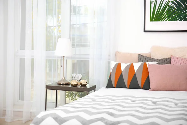 Cómoda cama con cojines en la habitación — Foto de Stock