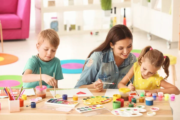 Happy family painting pictures at table indoors