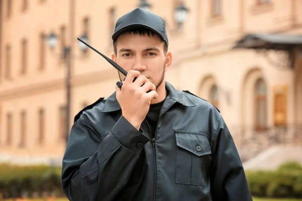 Mężczyzna ochroniarz przy użyciu przenośny nadajnik na zewnątrz — Zdjęcie stockowe