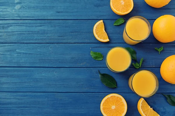 Composición con naranjas frescas y vasos de jugo —  Fotos de Stock