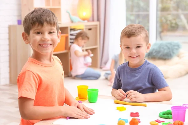 Meninos envolvidos em modelagem de massa de brincar na creche — Fotografia de Stock