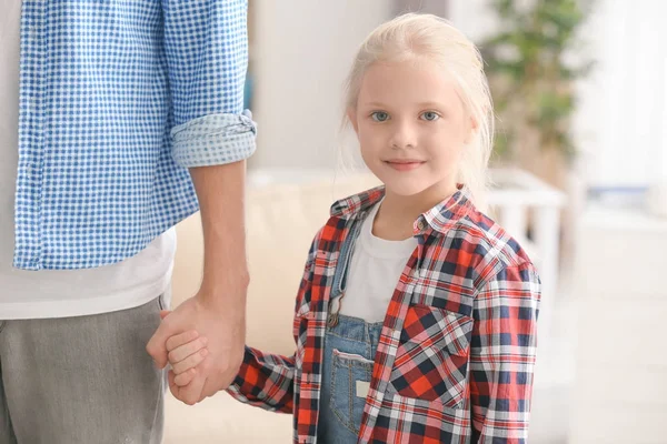 Bonito menina segurando a mão de seu pai em casa — Fotografia de Stock