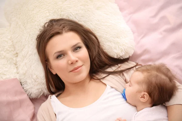 Jovem mãe e bebê bonito dormindo na cama em casa — Fotografia de Stock