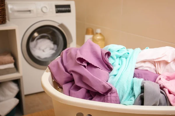 Mand met wasgoed op tafel in de badkamer — Stockfoto