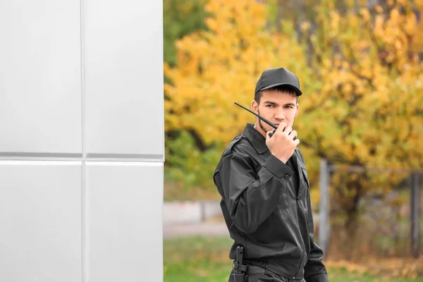 Mężczyzna ochroniarz przy użyciu przenośny nadajnik na zewnątrz — Zdjęcie stockowe