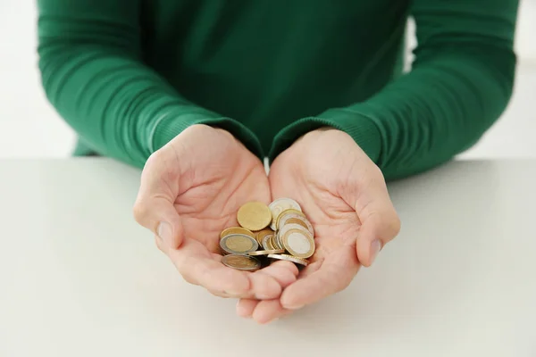 Man holding handful of coins over table, closeup — Stock Photo, Image