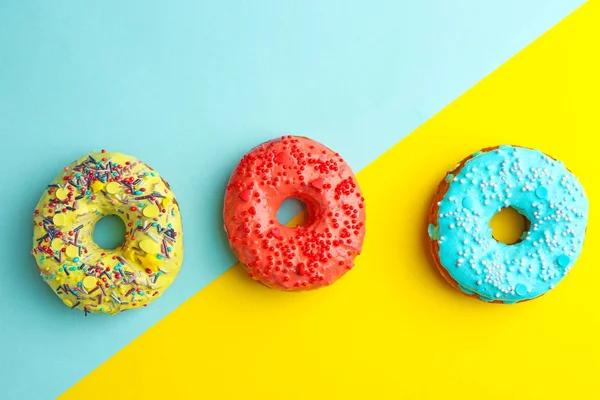 Смачні пончики зі зморшками на кольоровому фоні — стокове фото
