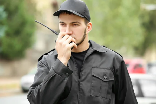 Guardia de seguridad masculino usando transmisor de radio portátil al aire libre — Foto de Stock