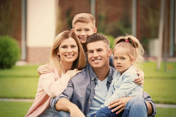 Lycklig familj på innergården nära deras hus — Stockfoto