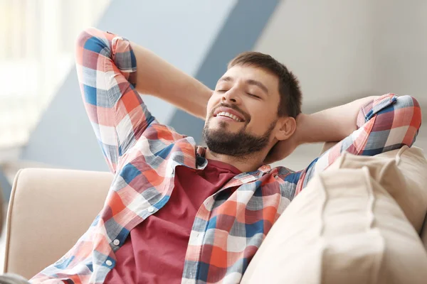 Snygg man som kopplar av på soffan hemma — Stockfoto