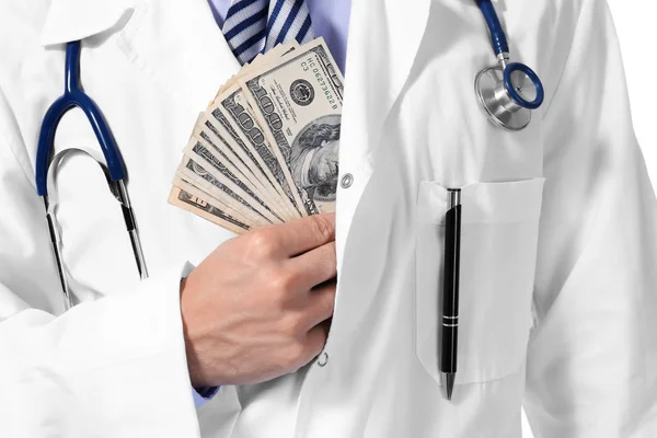 Médico colocando dinheiro no bolso no fundo branco, close-up — Fotografia de Stock