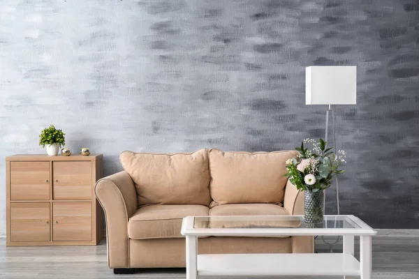 Стильный диван с белым столом в интерьере гостиной — стоковое фото