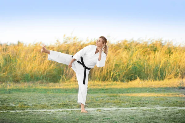 Mujer joven practicando karate al aire libre —  Fotos de Stock