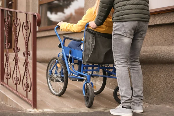 Ο άνθρωπος και η σύζυγός του σε αναπηρική καρέκλα σε ράμπα σε εξωτερικούς χώρους — Φωτογραφία Αρχείου