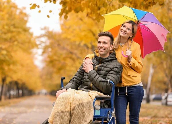 Femme avec son mari en fauteuil roulant à l'extérieur le jour de l'automne — Photo