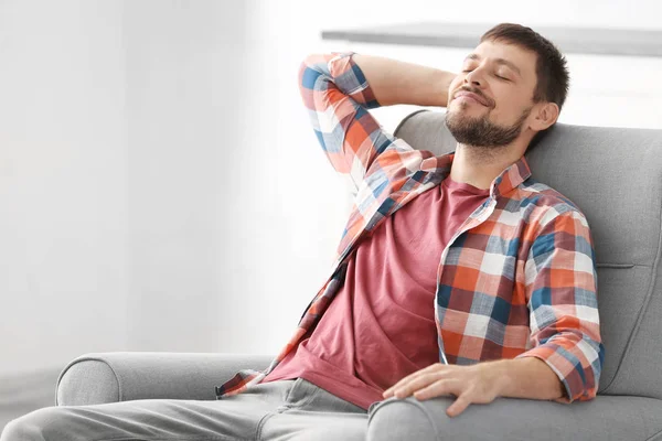 Hombre guapo relajándose en sillón en casa —  Fotos de Stock