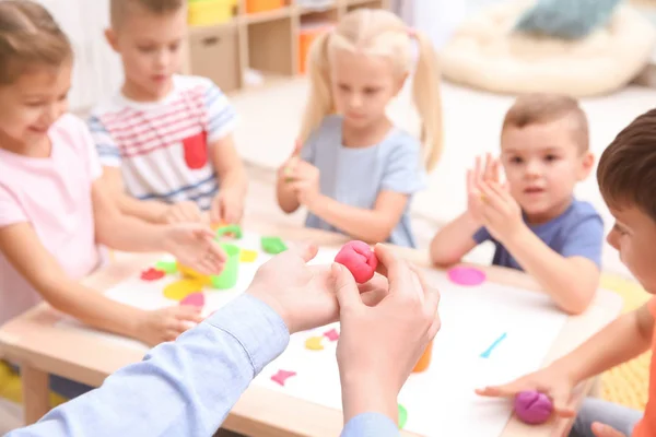 Małe dzieci zaangażowanych w playdough modelowania w przedszkolu — Zdjęcie stockowe