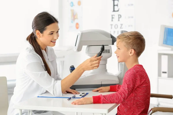 Oftalmólogo inspeccionando fondo de ojo de niño pequeño en clínica —  Fotos de Stock