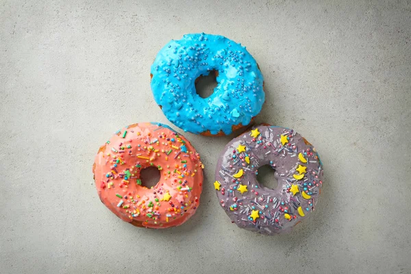Donuts colorés avec des saupoudres sur fond gris — Photo
