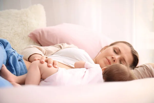 Jovem mãe e bebê bonito dormindo na cama em casa — Fotografia de Stock
