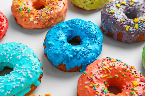 Donuts colorés savoureux sur fond blanc — Photo