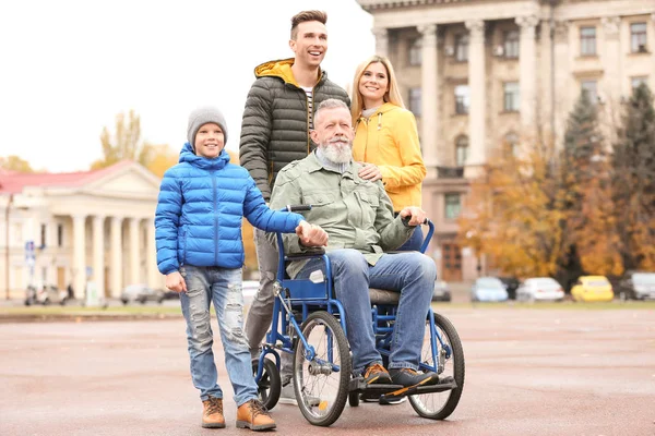 Bejaarde man in rolstoel met zijn gezin buiten op herfstdag — Stockfoto