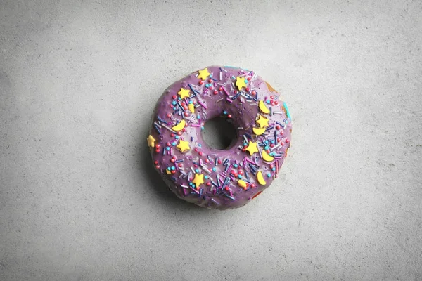 Lila donut med strössel på grå bakgrund — Stockfoto
