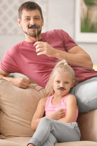 Linda niña y su padre con bigotes en los palos en casa — Foto de Stock