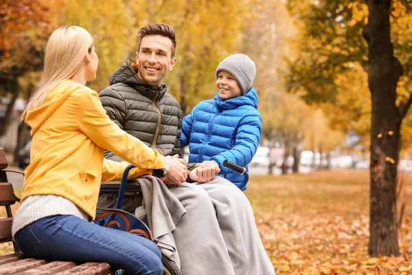 Man in rolstoel met zijn gezin buiten op herfstdag — Stockfoto