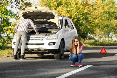 Kırık araba açık havada yakınındaki genç Çift