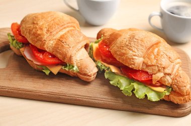 Ahşap tahta masada lezzetli kruvasan sandviç ile