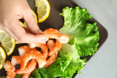 Lezzetli karides plaka üzerinde tablo üzerinde tutan kadın