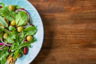 Ahşap arka plan üzerinde lezzetli sebze salatası ile plaka