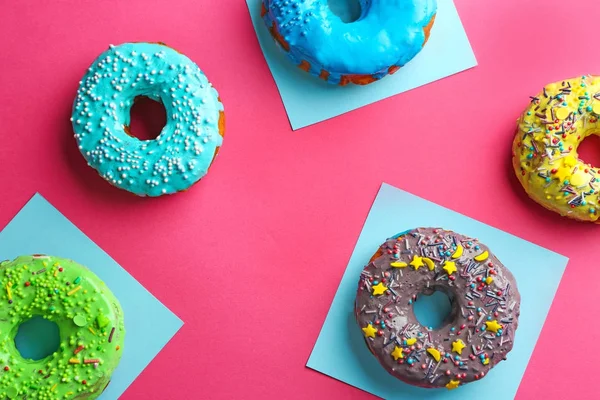 Donuts savoureux avec des aspersions sur fond de couleur — Photo