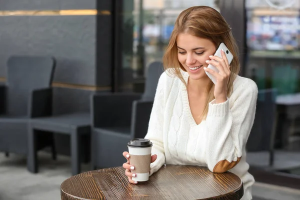 Bella giovane donna che parla al telefono cellulare in caffè — Foto Stock