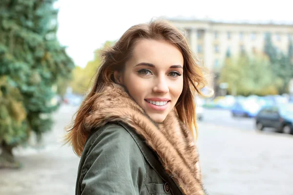 Belle femme souriante en veste avec col en fourrure à l'extérieur — Photo