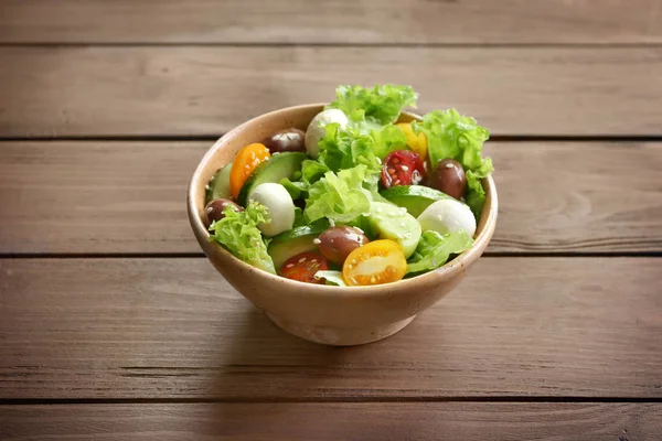 Tál ízletes zöldség saláta, fából készült háttér — Stock Fotó
