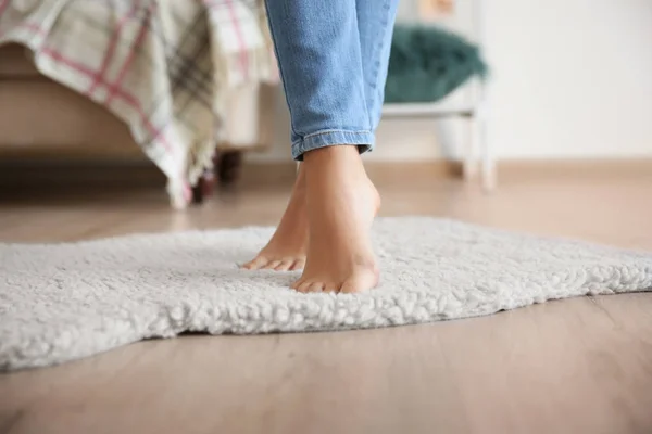 Mulher de pé no tapete branco macio em casa — Fotografia de Stock