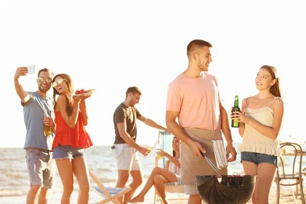 Jóvenes teniendo fiesta de barbacoa en la playa —  Fotos de Stock