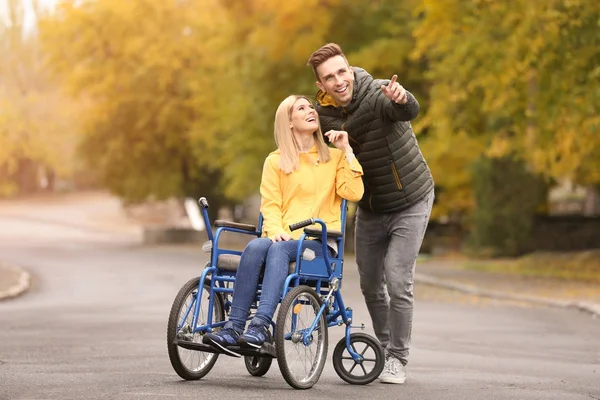 Homme avec sa femme en fauteuil roulant à l'extérieur le jour de l'automne — Photo