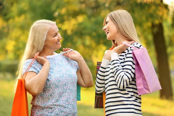 Mujer madura y su hija con bolsas de compras al aire libre —  Fotos de Stock