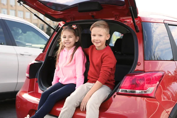 Cute children sitting in car trunk — Stock Photo, Image