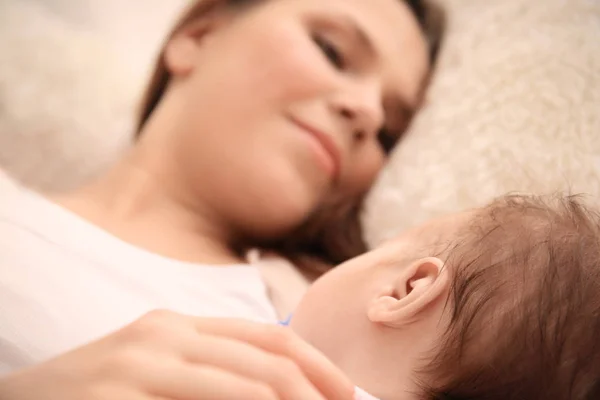 Ibu muda dan bayi tidur di tempat tidur di rumah — Stok Foto