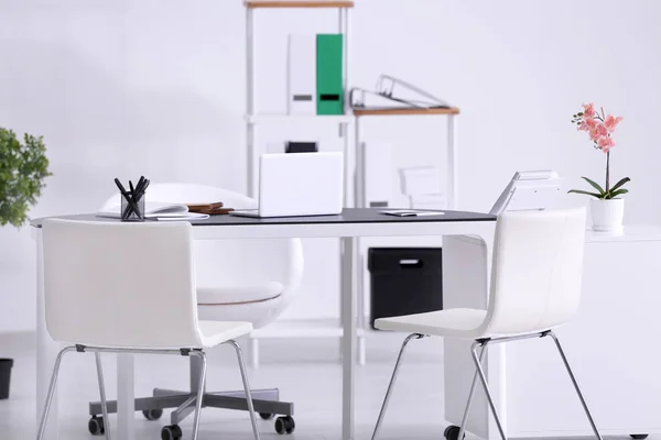 Современный офисный интерьер со столом и белыми стульями — стоковое фото