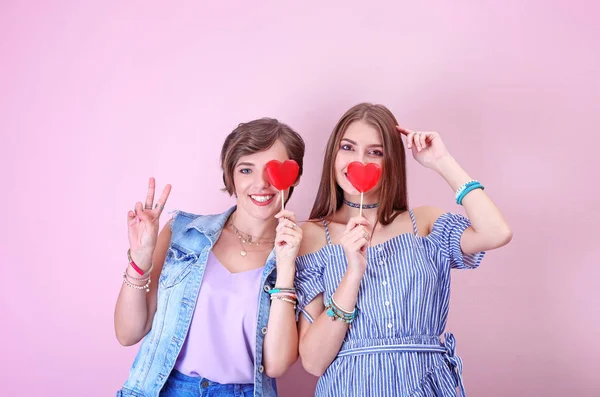 Ελκυστική hipster κορίτσια ποζάρουν με γλειφιτζούρια σε χρώμα φόντου — Φωτογραφία Αρχείου
