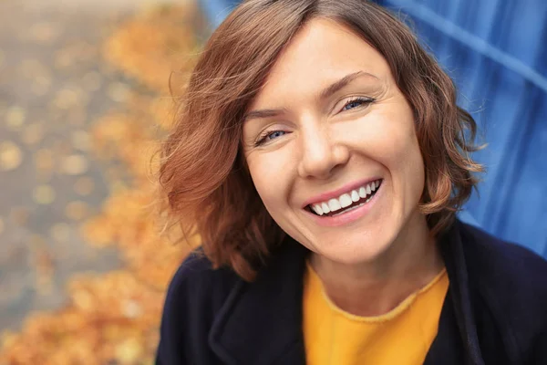 Bella donna sorridente in cappotto nero all'aperto — Foto Stock