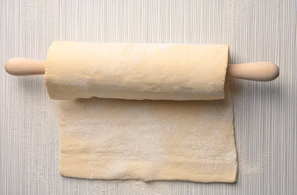 Raw puff dough and rolling pin — Stock Photo, Image