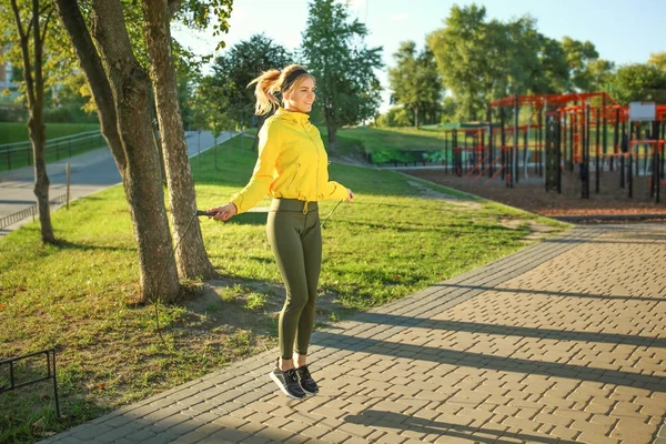 Jeune femme sportive saut à la corde dans le parc — Photo