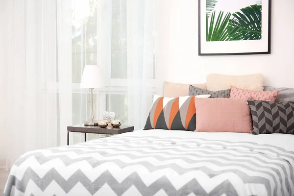 Cómoda cama con cojines en la habitación —  Fotos de Stock